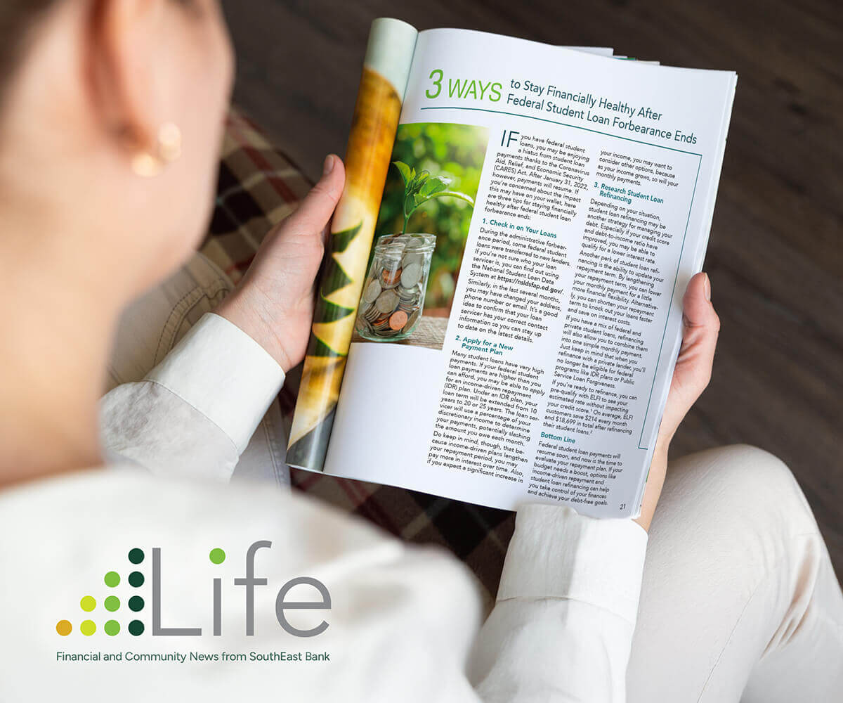 A woman reading a magazine with the word life on it.